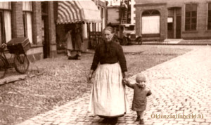 Oma Poorthuis aan de wandel 1898 op de Markt met links het pand van Chrisjan Ankone (t Kösterke), Boekhandel Bannink en de dames Fitzstum